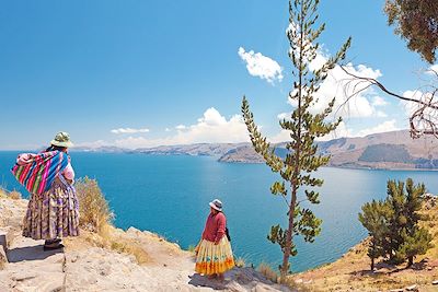 © Studioloco/stock.adobe.com - Femmes devant le lac Titicaca - Département de La Paz - Bolivie Femmes devant le lac Titicaca - Département de La Paz - Bolivie