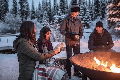 Famille autour d'un feu en plein hiver - Canada