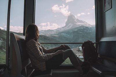 Femme dans un train dans les Alpes Suisse
