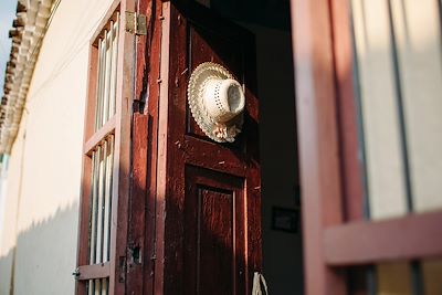 © Gabriel Tichy / Stocksy - Chapeau sur une porte chez l'habitant à Cuba Chapeau sur une porte chez l'habitant à Cuba