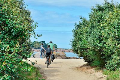 Randonneurs en vélo sur la Côte de Granit Rose en Bretagne - France