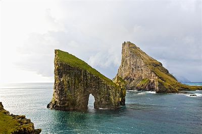 © Morten Abrahamsen / Visit Faroe Islands  - Le rocher de Drangarnir entre les îles Tindholmur et Vagar - Iles Féroé Le rocher de Drangarnir entre les îles Tindholmur et Vagar - Iles Féroé