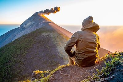 Homme regardant le paysage du volcan Fuego en éruption au Guatemala