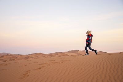 Enfant jaunt dans les dunes du désert marocain