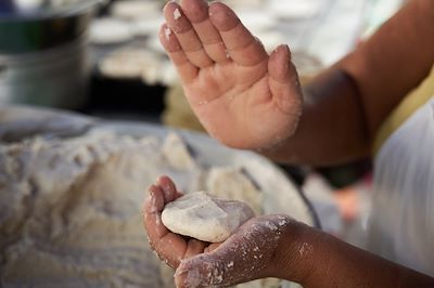 Une femme prépare des pupusas sur un marché de rue au Salvador