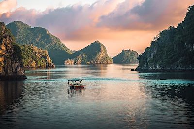 Bateau sur la baie d'halong au coucher du soleil