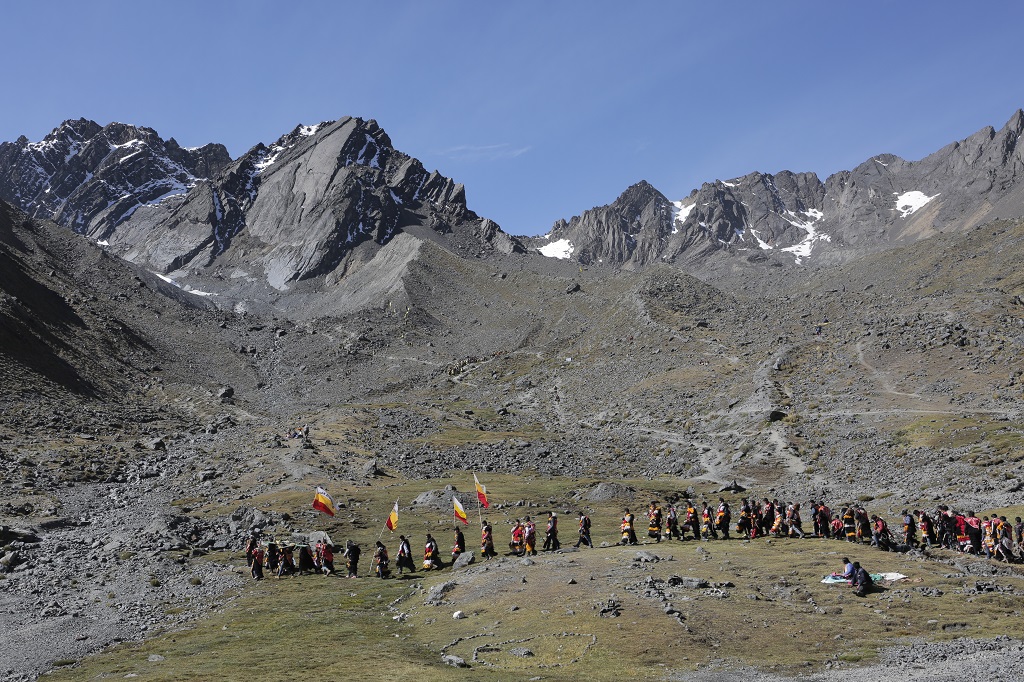 Au petit matin, les initiés, en transe, partent vers le glacier. La pente est très raide. Malgré l’altitude, beaucoup courent ou dansent à travers les éboulis en portant des croix ou de lourds étendards. - ©Alfred de Montesquiou