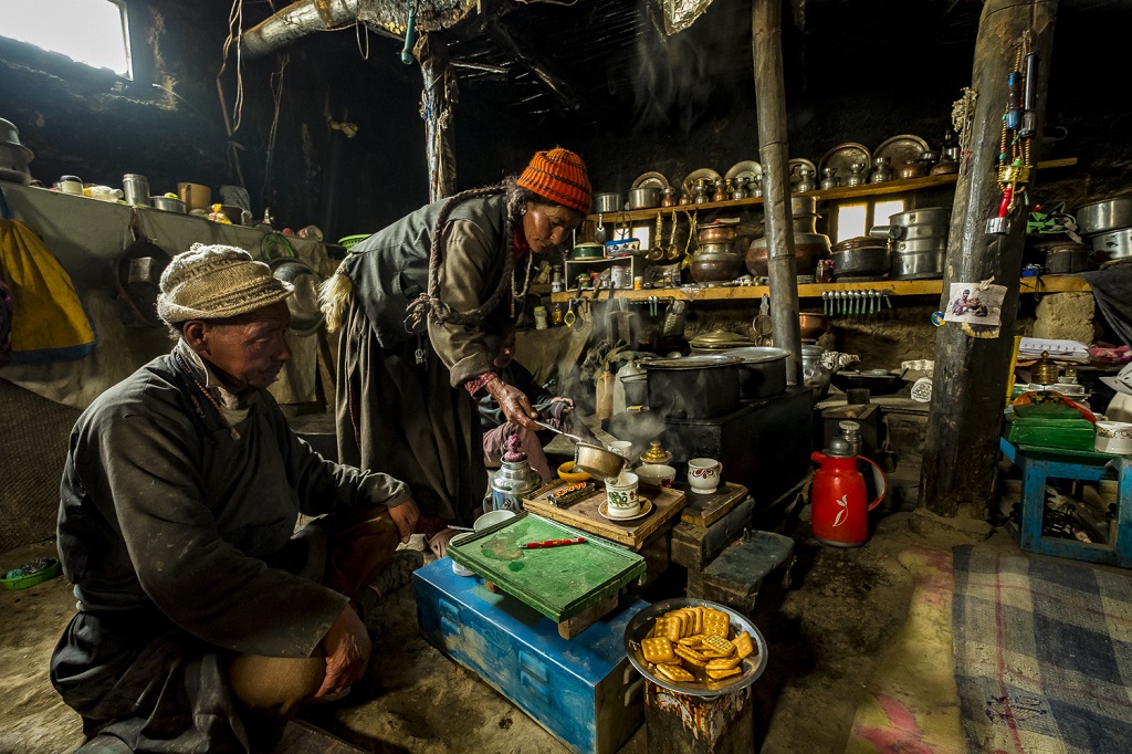 Hospitalité toute ladakhie dans la demeure enfumée et "dans son jus" de Siri Angchuk et son épouse Kunzes Dolma, en train de servir le thé au beurre salé à un photographe de passage