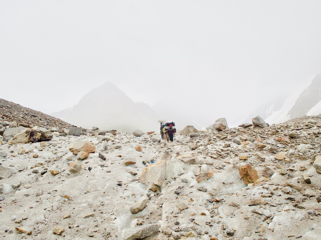 Glacier du Baltoro. Les porteurs serpentent entre les éboulis. Pour cette expédition de douze trekkeurs, ils étaient une vingtaine à nous accompagner. - ©Philippe Barthez